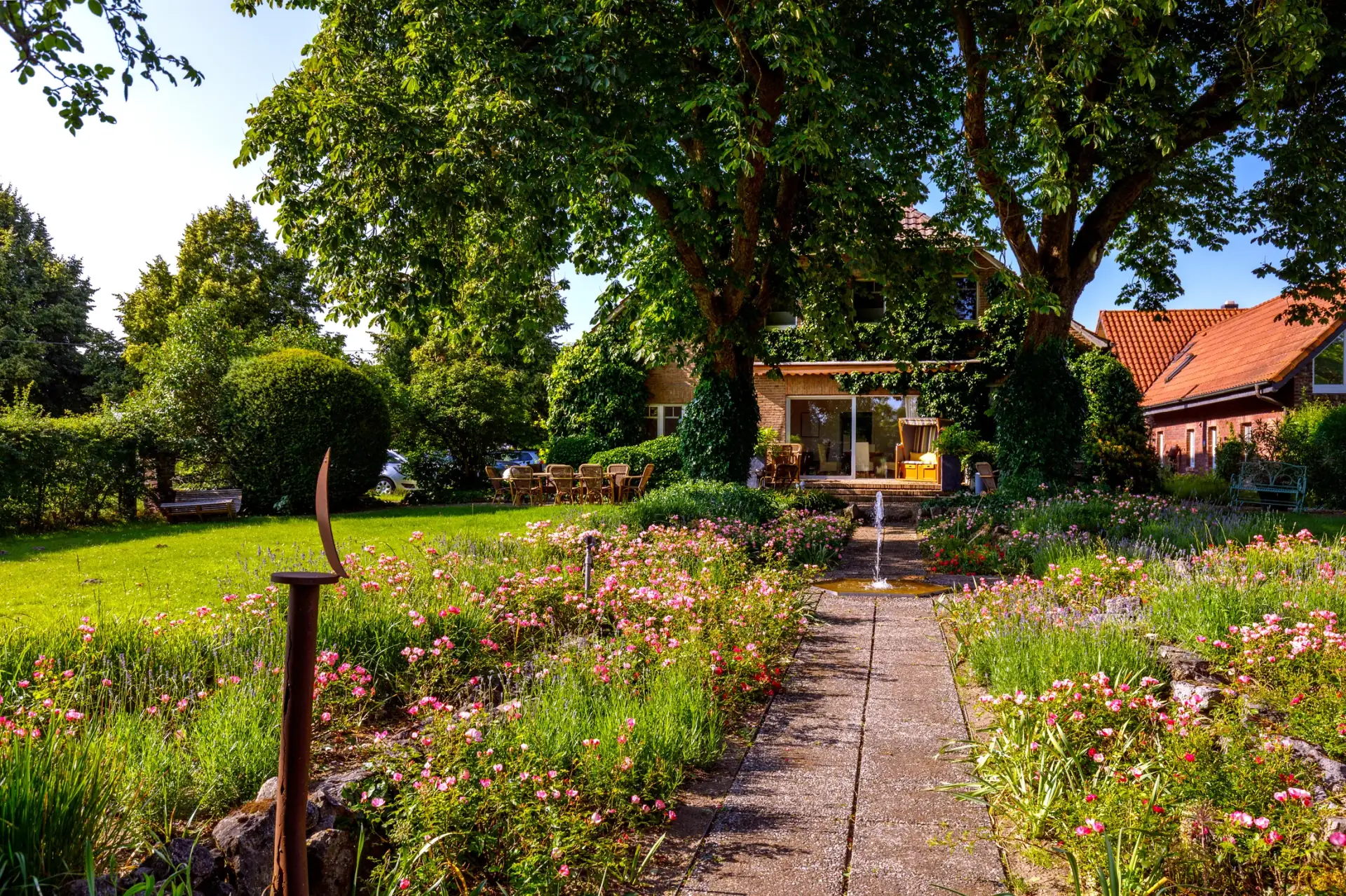 Blühender Garten und Weg zum Drostenhof unter alten Bäumen