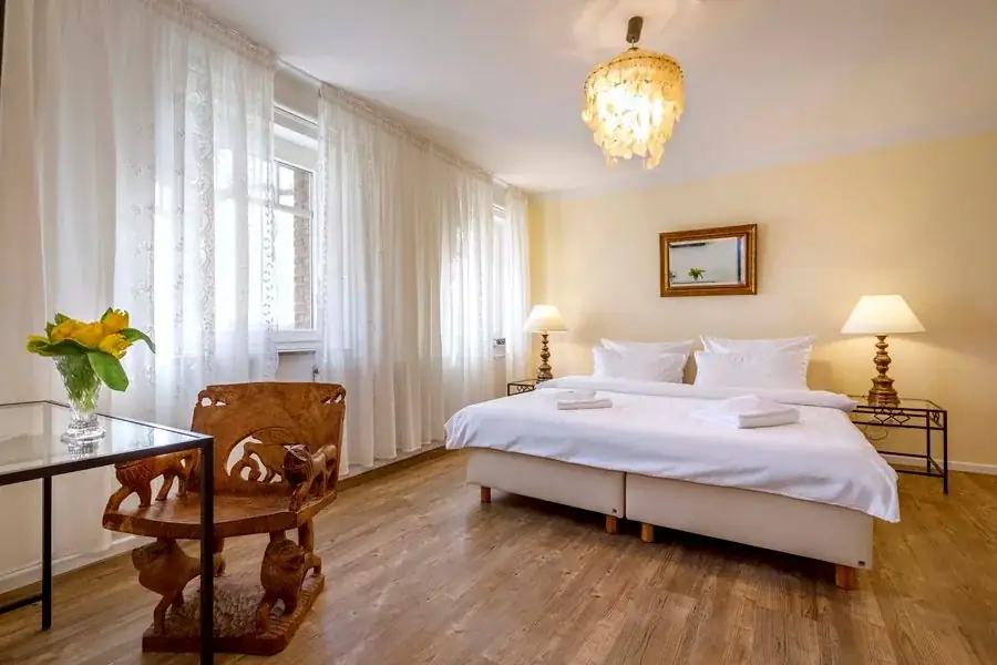 Gelbes Zimmer mit Doppelbett und Sitzbereich