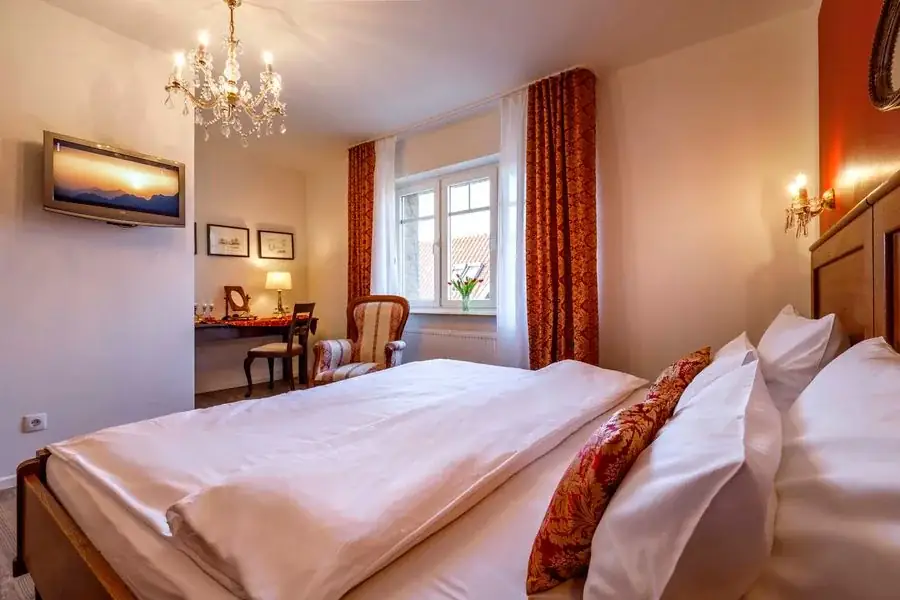 Rotes Zimmer mit Doppelbett und warmen Farbtönen